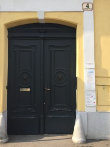 Hauseingang Eine hohe, doppeltürige Eingangstüre in dunkelgrün in einem gelb gehaltenen Haus
